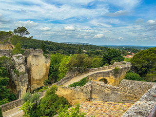 Fototapeta premium A OLD BRIDGE AND ROADWAY AMONGST RICH FOLIAGE WITH A NICE SKY IN FRANCE IN THE PROVENCE REGION