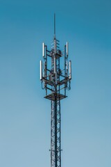 A Tall Cellular Tower Against A Clear Blue Sky