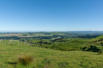Naklejka premium Wide view across rural farmland to distant coast