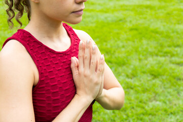 Close-up of unrecognizable hispanic caucasian woman doing yoga session in the nature with hands in...