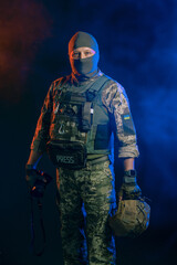 Naklejka premium Military reporter in tactical uniform with a camera in his hands on a dark background