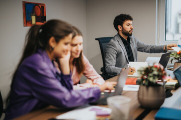 Fototapeta premium A multicultural team of young entrepreneurs analyzes statistics and works on a project during a business meeting at a startup office.