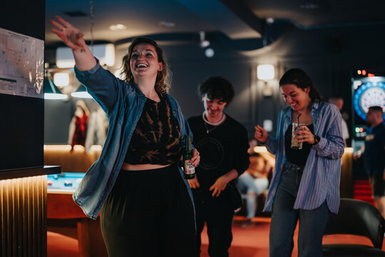 A group of young adults enjoy a lively game of darts in a cozy bar setting, sharing laughter and drinks on a joyful night out.