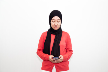 Portrait of young Muslim woman in pink sweeter and using telephone. isolated on a white background