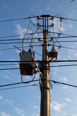 Electric post facing bright blue summer sky with blue sky background