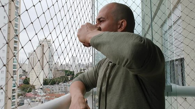 48 year old Brazilian with a headache and drinking coffee on the balcony.
