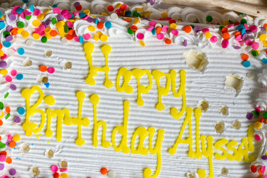 Happy Birthday Alyssa birthday cake with white frosting and rainbow sprinkles 