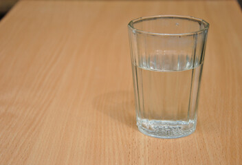 glass with water. glass of water on the table. dark photo