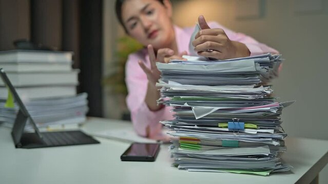 Stressed office worker overwhelmed by a massive stack of paperwork, showing signs of frustration and stress. Depicts heavy workload in a corporate setting