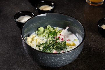Refreshing Ayran-Based Okroshka with Fresh Vegetables in Dark Bowl