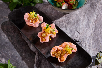 Salmon Tartare on Rice Chips - Gourmet Appetizer on Slate Plate with Fresh Herbs