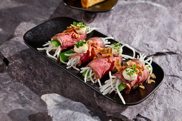 Elegant Appetizer of Roast Beef Roll with Daikon and Cucumber on Slate Plate