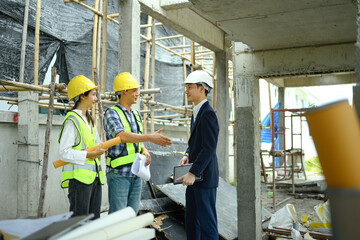 Businessmen or investor having a conversation and shaking hands with engineer team construction site