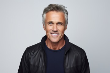 Obraz premium Handsome middle aged man in black leather jacket over grey background.