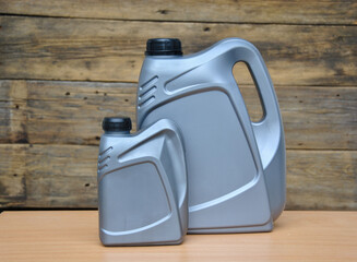 large and small plastic canisters for car oil on a wooden background