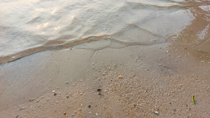 Close up soft wave lapped the sandy beach. natural abstract background and texture