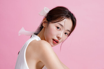 ピンク背景で撮影をした若い女性の軽やかなビューティー ポートレート
