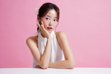 ピンク背景で撮影をした若い女性の軽やかなビューティー ポートレート