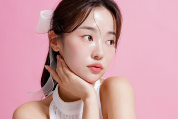 ピンク背景で撮影をした若い女性の軽やかなビューティー ポートレート