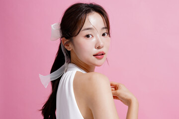 ピンク背景で撮影をした若い女性の軽やかなビューティー ポートレート