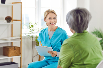 Caring kind smiling nurse, geriatric medicine providing senior woman help, support to aged old granny on medical visit, doctor, test result on clipboard, discussing healthcare insurance, treatment 