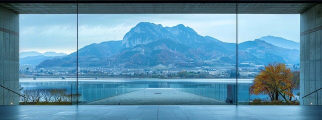  A room offering a vista of a mountain range and a body of water in the foreground, along with a cityscape in the background