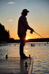a fisherman catches a fish on a river on a summer day