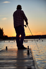 a fisherman catches a fish on a river on a summer day