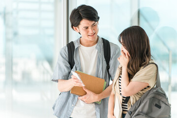 スマホを見ながら会話する学生・大学生の男女（泣く・困る・悲しい・落ち込む・悔しい））
