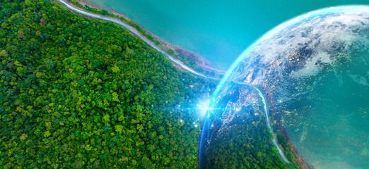 Idyllic winding road through the green pine forest. Aerial view of beautiful natural Road and green field in the wild forest mountain near Lake.