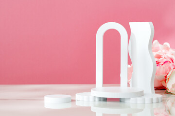 Decorative podiums against pink background in studio