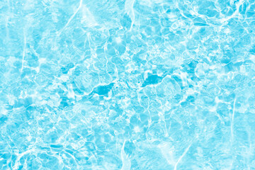 Blue water with ripples on the surface. Defocus blurred transparent blue colored clear calm water surface texture with splashes and bubbles. Water waves with shining pattern texture background.