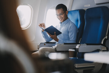 Airplane, travel and portrait of businessman working on laptop computer and smartphone while sitting in airplane.