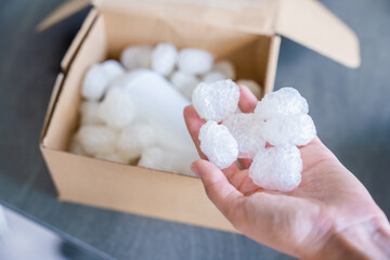 Eco packaging of parcels and white biodegradable filler. Box is filled with a filler safety for...