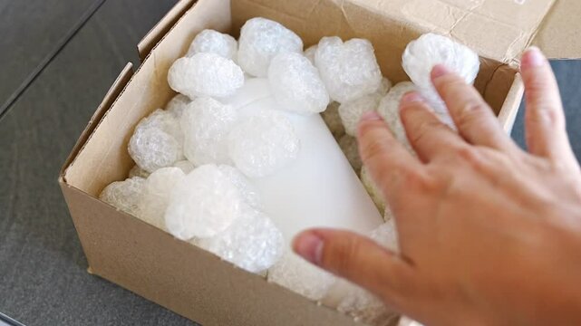 Eco packaging of parcels and white biodegradable filler. Box is filled with a filler safety for environment. Delivery of goods, parcels, delivery service, nature protection and recycling concept