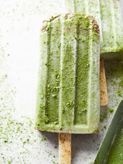 close-up view of homemade matcha green tea popsicle with chocolate chips and matcha powder sprinkled