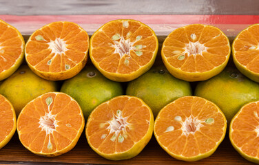 ripe tangerines with green peel as background.