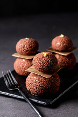 cacao Chocolate Puff balls with fork served in dish isolated on dark background side view of baked cafe food
