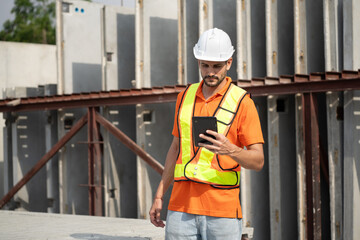 Portrait Hispanic latin engineer man use tablet computer checking precast cement at precast cement outdoor factory	