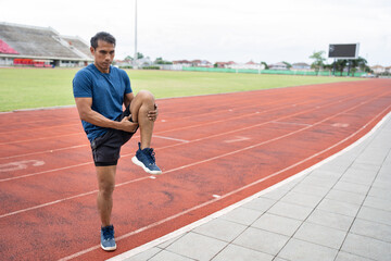 Fototapeta premium Mature fitness Asia man runner stretching legs before run on racetrack