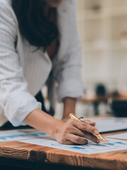 Happy young asian businesswoman sitting on her workplace in the office. Young woman working at laptop in the office.
