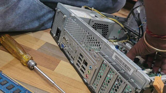 A man is repairing a desktop computer. The concept of computer repair. Close up of unidetified man repair computer motherboard with a screwdriver. Maintenance of the hardware of the motherboard.