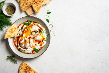 Turkish eggs Cilbir and fresh pita bread
