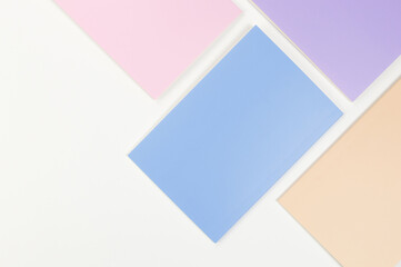 Top view of pink, purple, blue and beige notebooks on white background. School, office wallpaper. Flat lay, copy space.