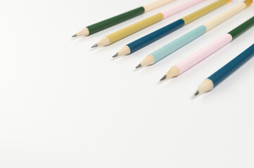 Top view of colorful pencils on white background. School, office, art wallpaper. Flat lay, copy space.