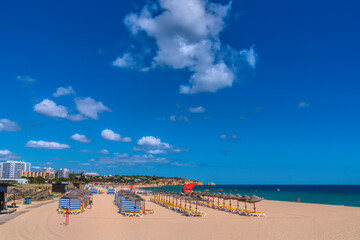 Obraz premium Alvor Portugal beautiful sandy beach with umbrellas and sun loungers the Algarve between Portimao and Lagos