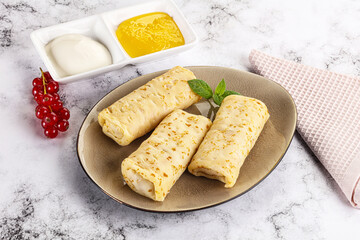 Homemade stuffed pancakes with honey and cream sour