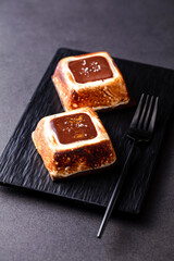 Toasted Marshmallow Chocolate Tart with fork served on board isolated on dark background side view...