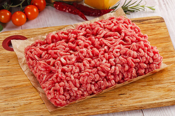 Raw minced beef meat over board