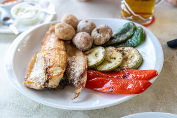 Papas arrugadas sea water boiled potatoes, grilled fish and vegetables, red mojo, green mojo, dining table